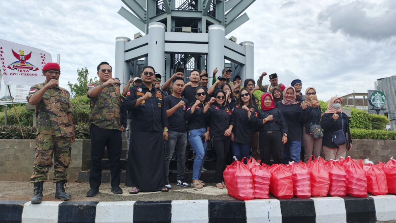 Anggota DPC GRIB Jaya Cilegon membagikan ratusan nasi bungkus kepada pengguna jalan dan masyarakat di Simpang Tiga. (Istimewa) 