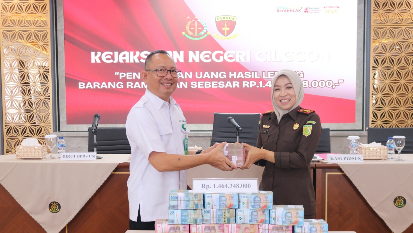 Kepala Kejari Kota Cilegon Diana Wahyu Widiyanti saat menyerahkan uang hasil korupsi ke Direktur Utama BPRS - CM Novran Erviatman Syarifudin. (Foto:Istimewa) 