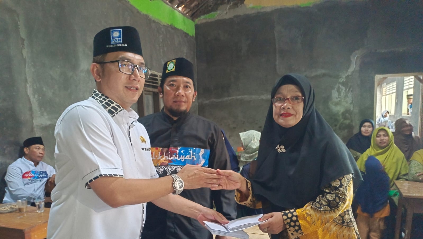 Anggota DPRD Kota Cilegon, Rahmatullah menyerahkan uang donasi kepada guru madrasah yang ada di Kecamatan Purwakarta. (Foto:Babebanten.com)