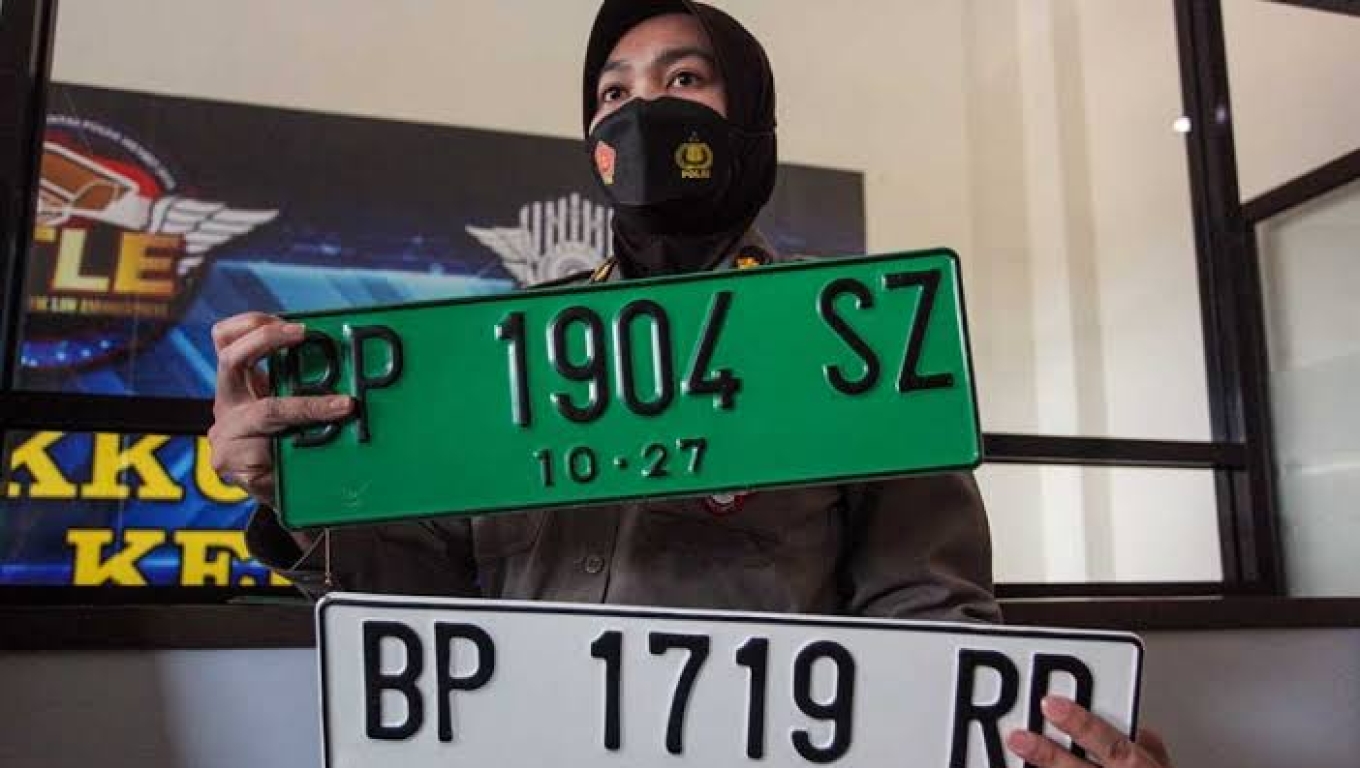 Personel Ditlantas Polda Kepri memperlihatkan Tanda Nomor Kendaraan Bermotor berwana Putih dan Hijau. (Dok: Okezone) 