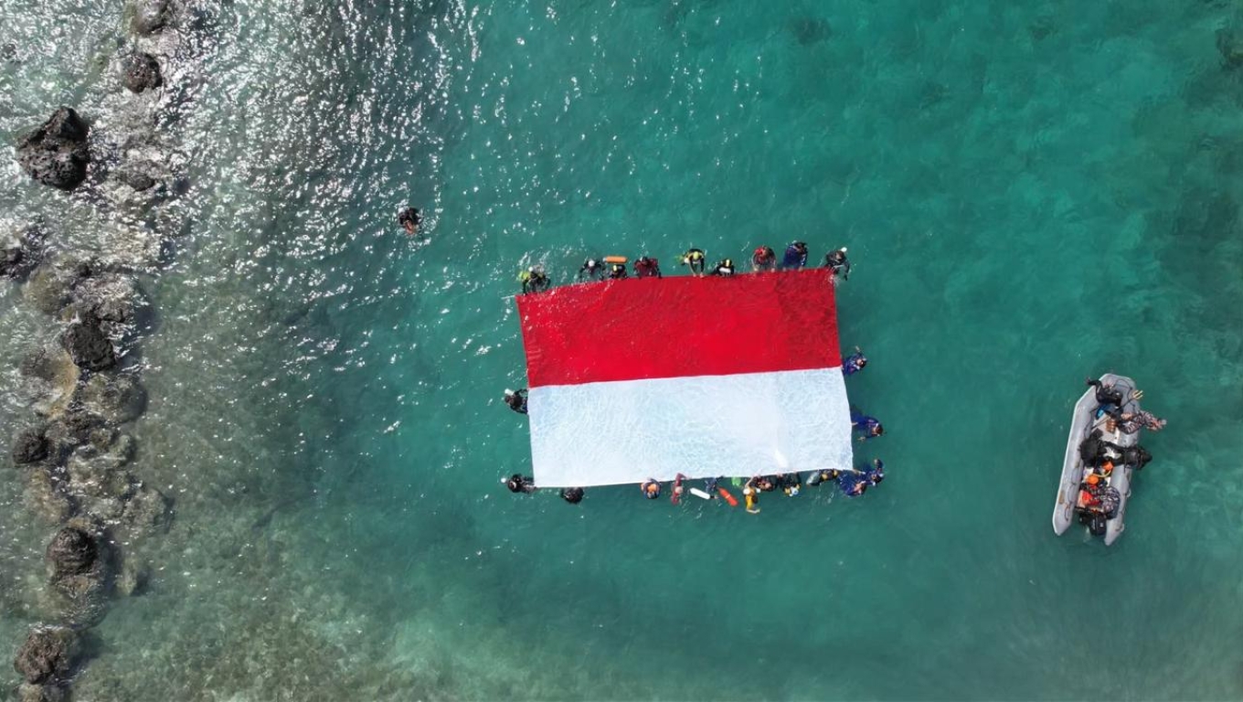 Bendera Merah Putih terbentang di laut Pulau Sangiang, Kabupaten Serang. (Foto: Istimewa)