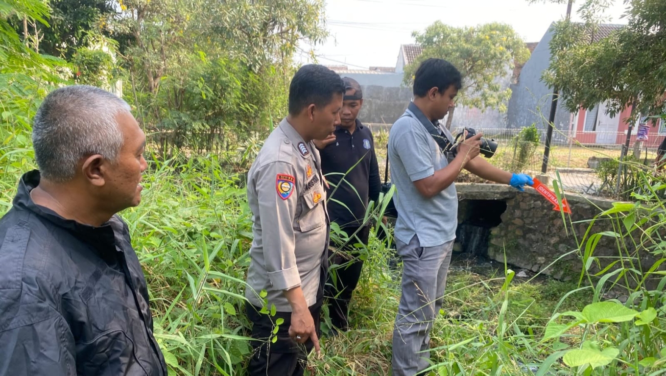 Polisi saat melakukan olah TKP di lokasi ditemukannya bayi di pinggir sungai Perumahan Metro Cilegon. (Foto: Istimewa) 