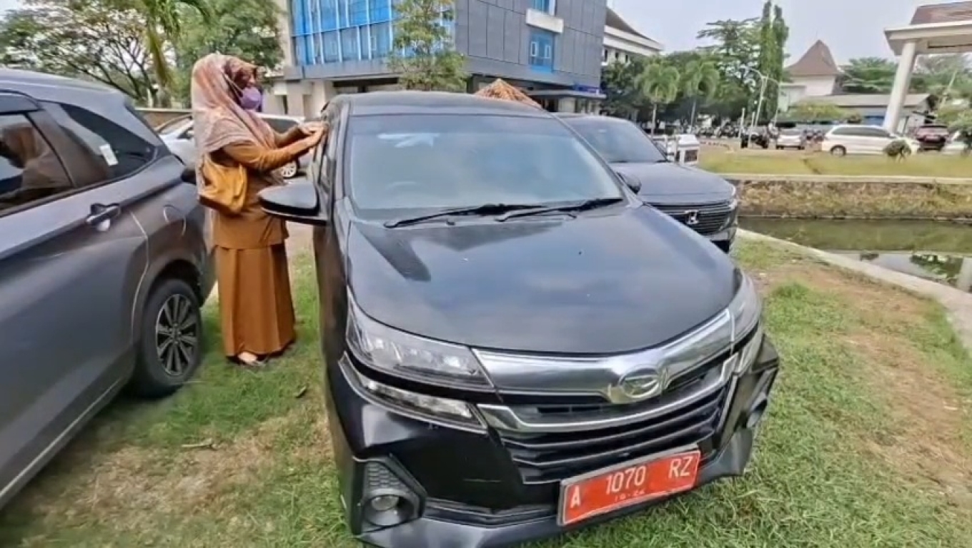 Petugas UPT Samsat Cilegon saat menempel stiker tagihan pajak pada kendaraan plat merah. (Foto: Babe Banten )